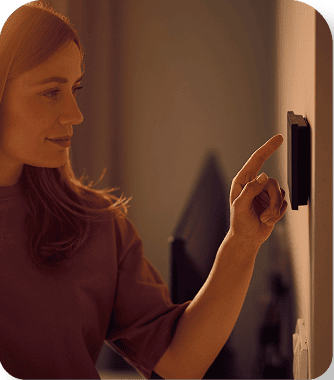 Woman adjusting smart thermostat