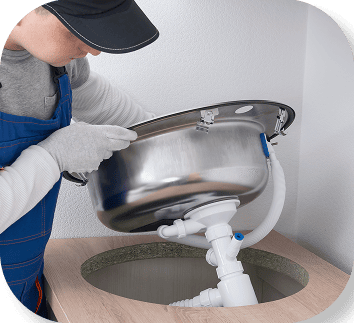 Plumber working under a sink basin