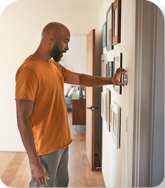 Man adjusting smart thermostat