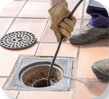 Plumber using a sewer camera inspection tool outdoors