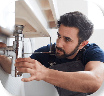 Plumber fixing a pipe under a sink
