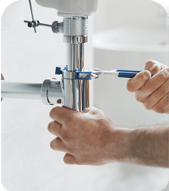 Plumber fixing a pipe under a sink