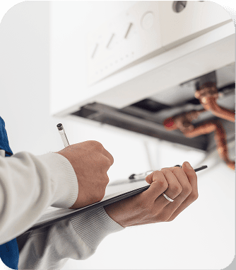 Plumber inspecting pipes and writing on clipboard