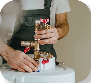 Close up of a plumber's hands working on water heater valves